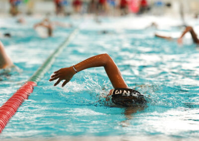 Jeune nageur en plein effort portant le bonnet en tissu personnalisé des 24 heures de natation